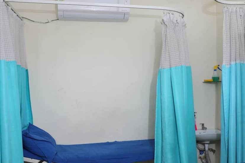 A made-up bed behind curtains in the ward at Caspian Healthcare