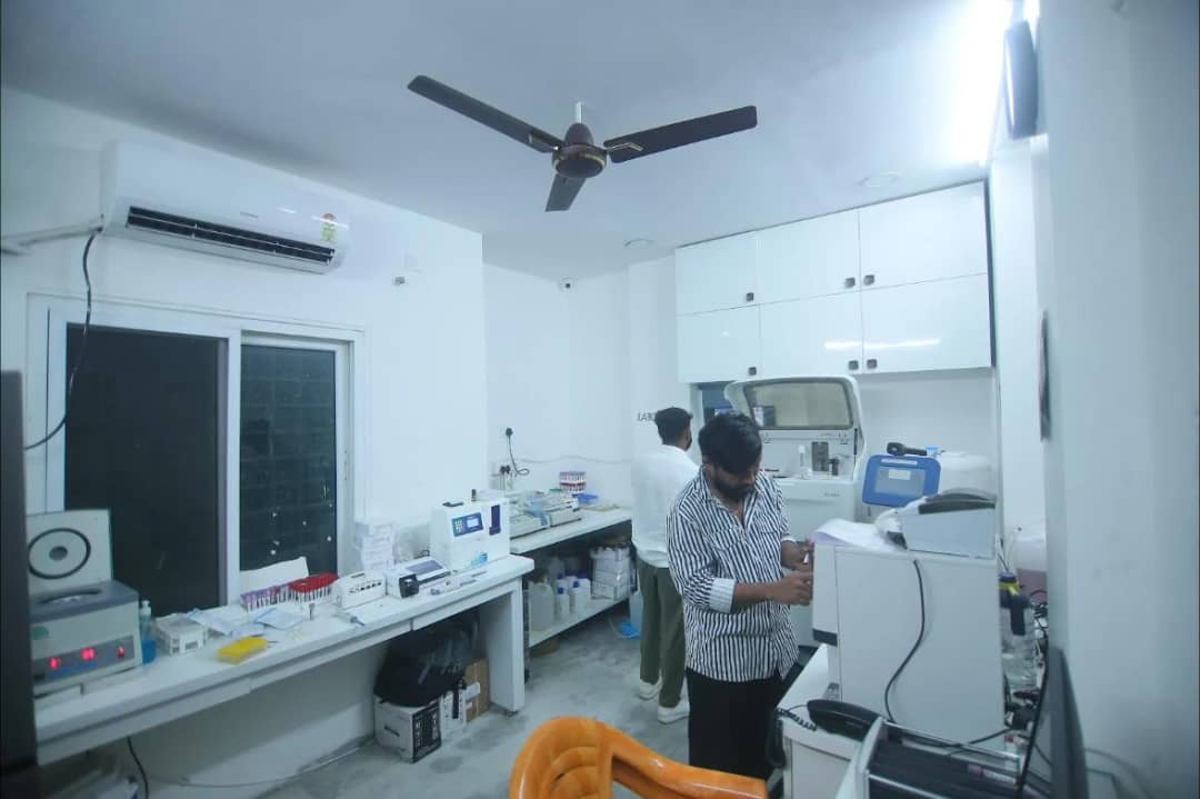 Sample racks, a centrifuge and analysers in the laboratory at Caspian Healthcare