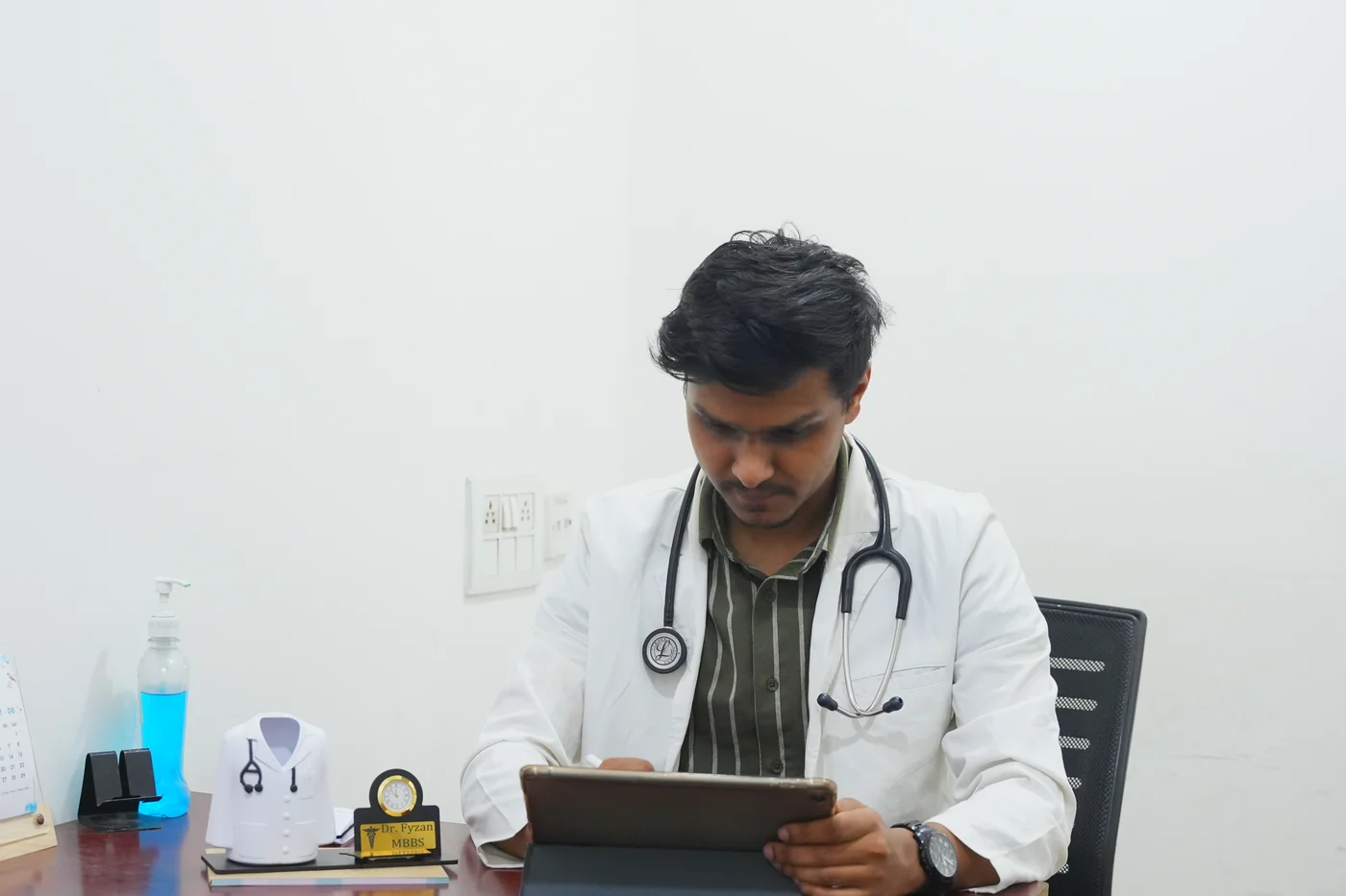 The duty medical officer at his desk in the outpatient room at Caspian Healthcare, Vijay Nagar Colony, Hyderabad