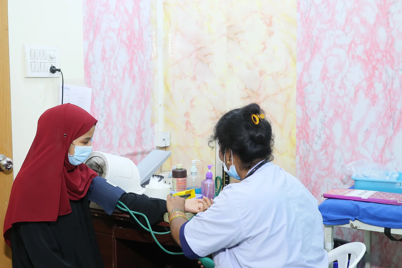 A nurse taking a patient's blood pressure in the outpatient room at Caspian Healthcare, Vijay Nagar Colony, Hyderabad